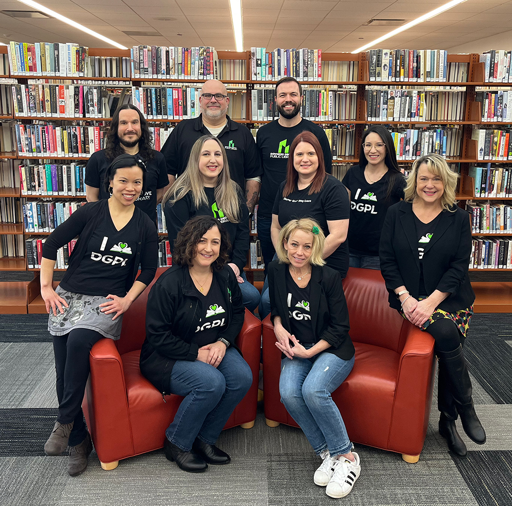 The Downers Grove Public Library Management team smiling wearing Downers Grove Public Library shirts.